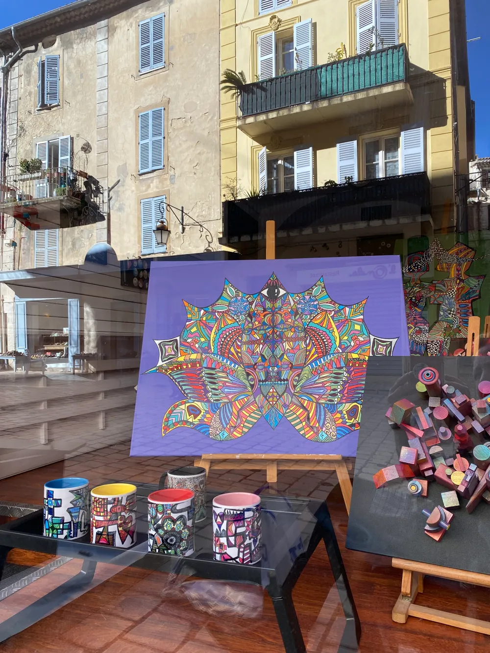 Contemporary art display at Galerie Joie De Vivre with a painted lotus and mug sculptures